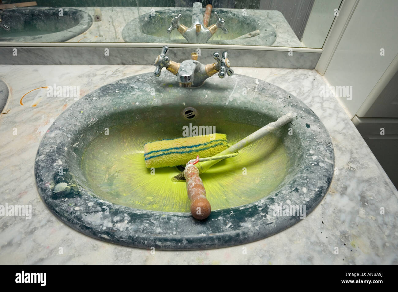 A bathroom sink made dirty by roller painting works. Evier de salle de bain  sali par des travaux de peinture Stock Photo - Alamy