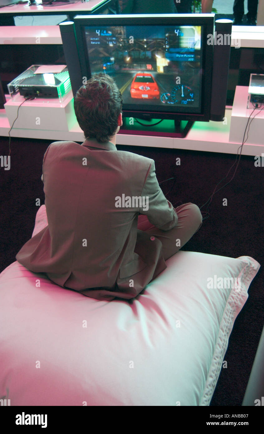 man in business suit playing computer simulation game at EXPO 2004 tradeshow in Hannover Germany Stock Photo