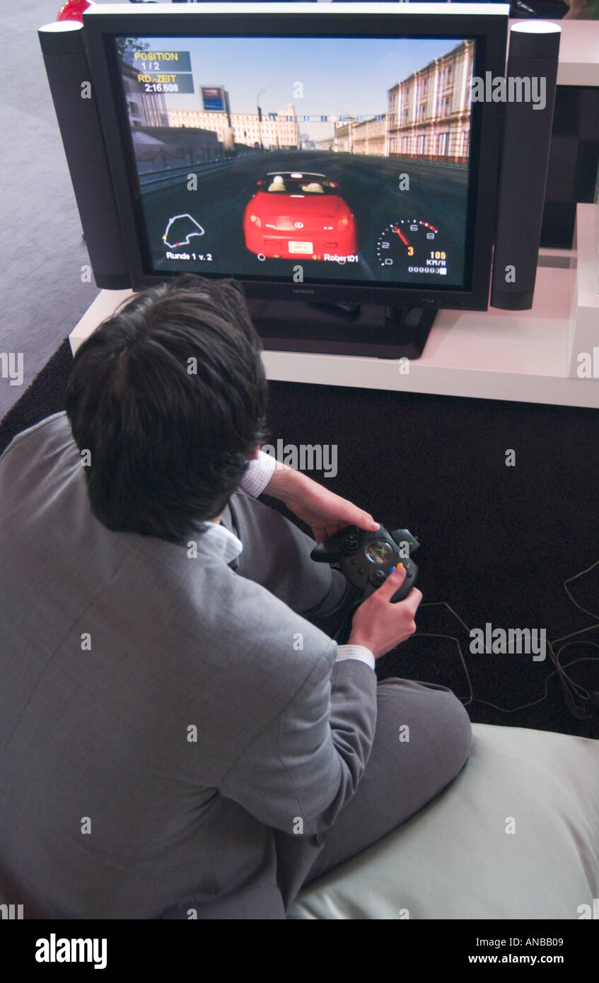 man in business suit playing computer simulation game at EXPO 2004 tradeshow in Hannover Germany Stock Photo