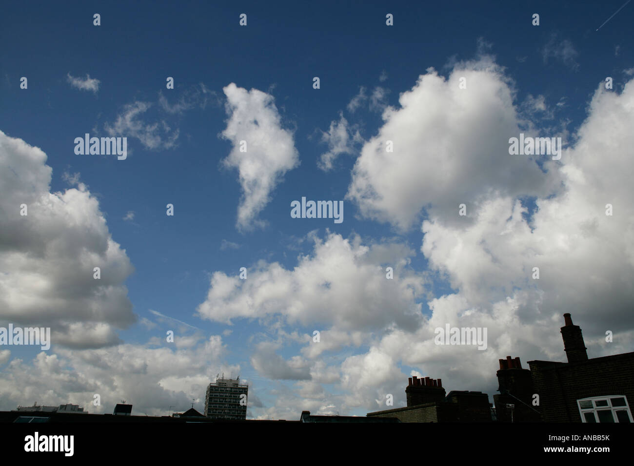 Fluffy white clouds on a blue sky over a London skyline in England UK Stock Photo