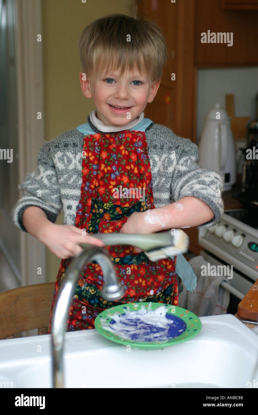 1 of 4 sequence four year old boy washes the dishes at home Stock Photo
