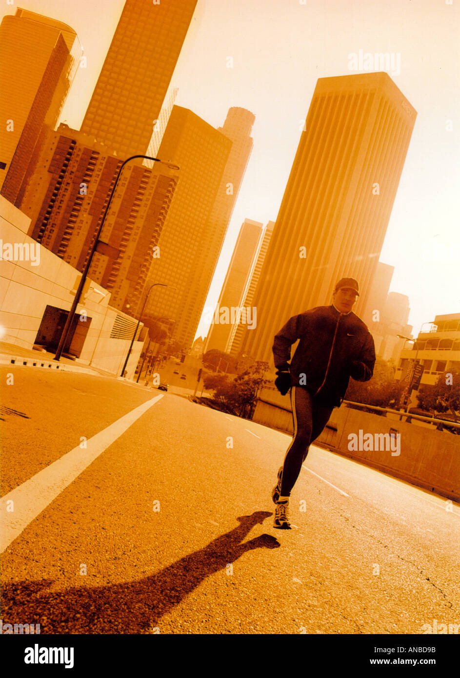 Man wearing running clothes runnig on street in downtown urban setting ...