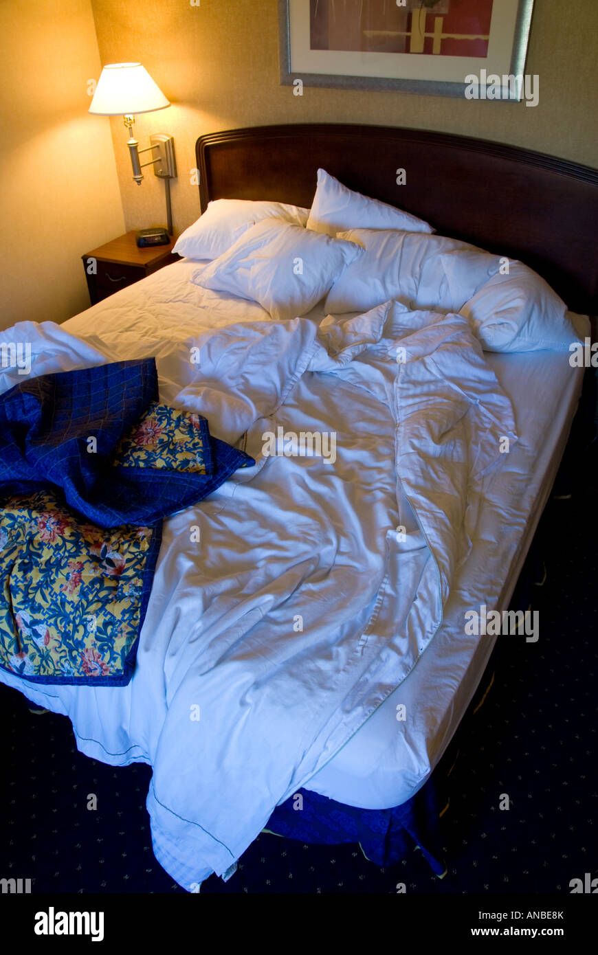 High Angle View Of Unmade King Sized Hotel Room Bed With