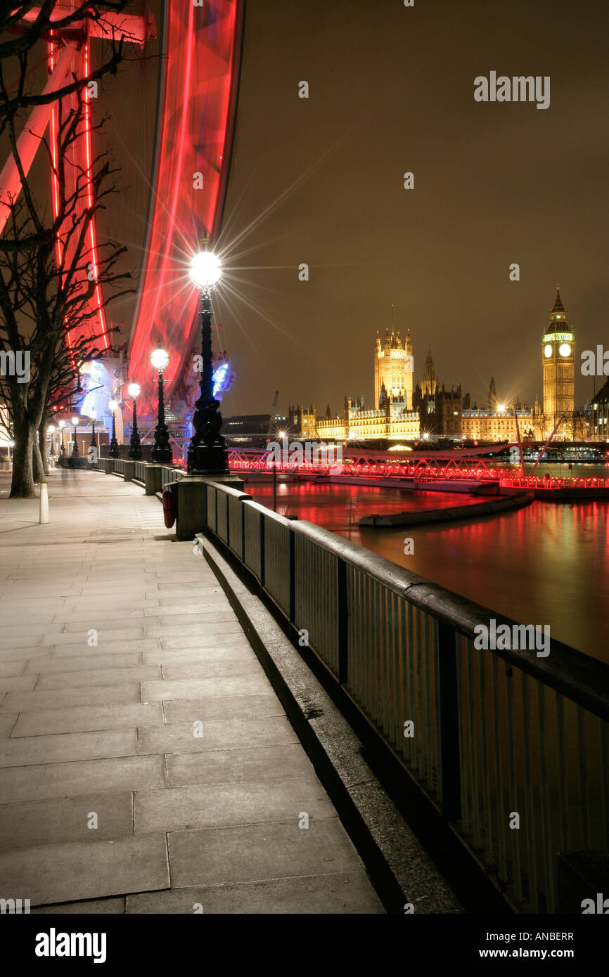 The London eye on the river Thames in London UK with the palace of Westminster in the background at night Stock Photo