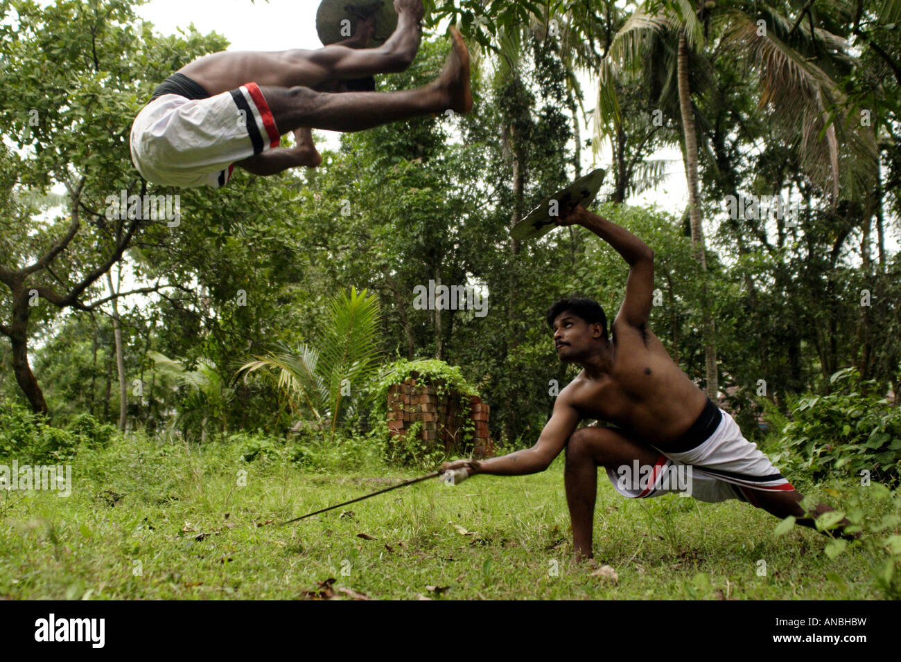 Two men practice the ancient martial art of Kalarippayattu in Kerala. Athleticism is very much required for Kalarippayattu. Stock Photo