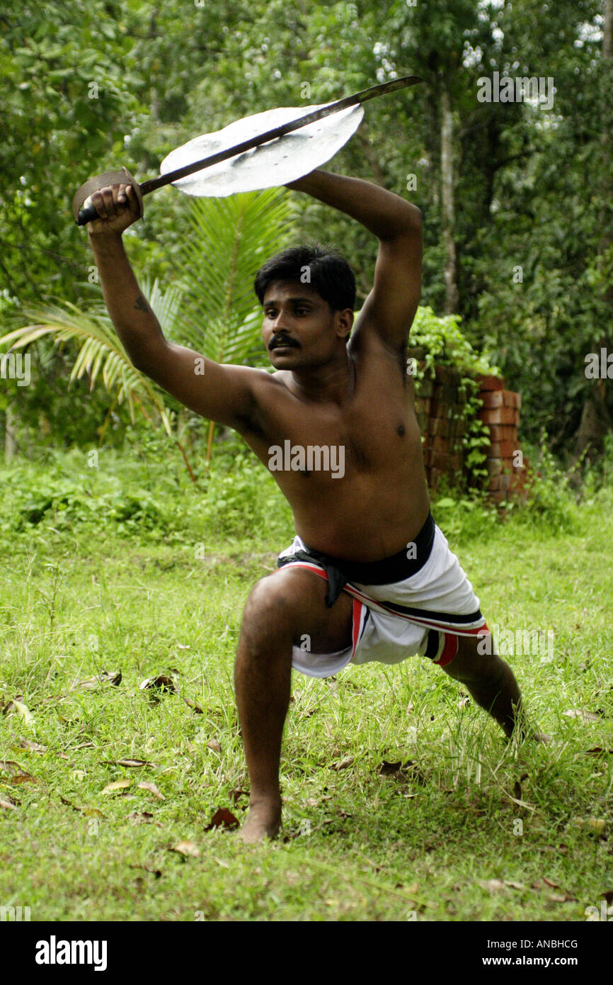 A man practices the ancient martial art of Kalarippayattu in Kerala, India. He is a defensive stance. Stock Photo
