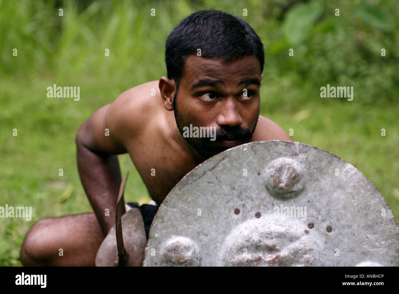 A man practices the ancient martial art of Kalarippayattu in Kerala, India. He is a defensive stance. Stock Photo
