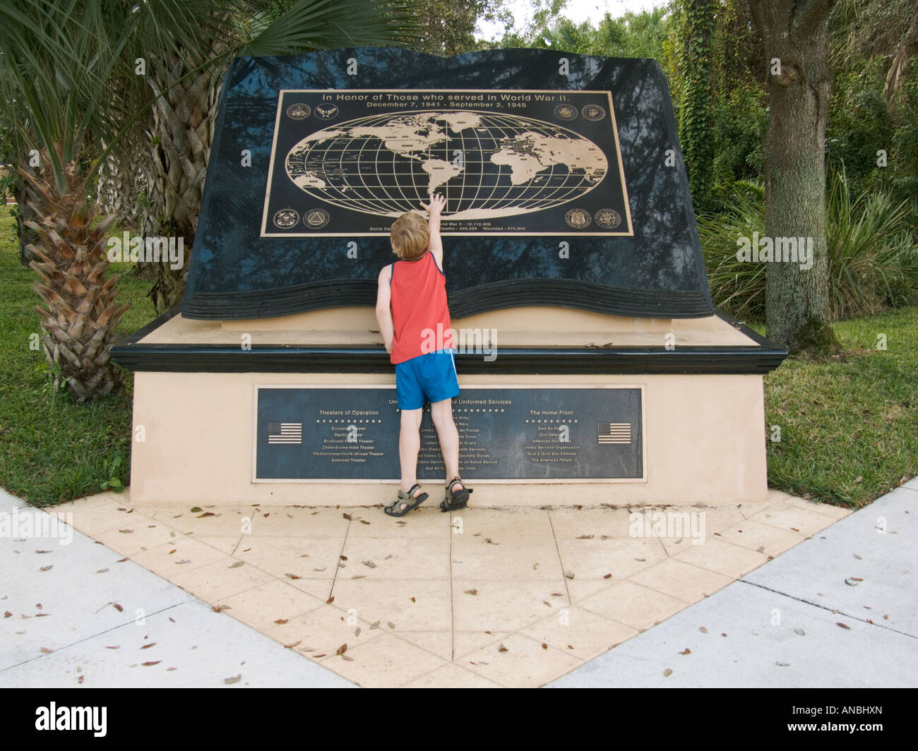 boy looking at touching world war two WWII two memorial monument world map learning education history freedom Stock Photo