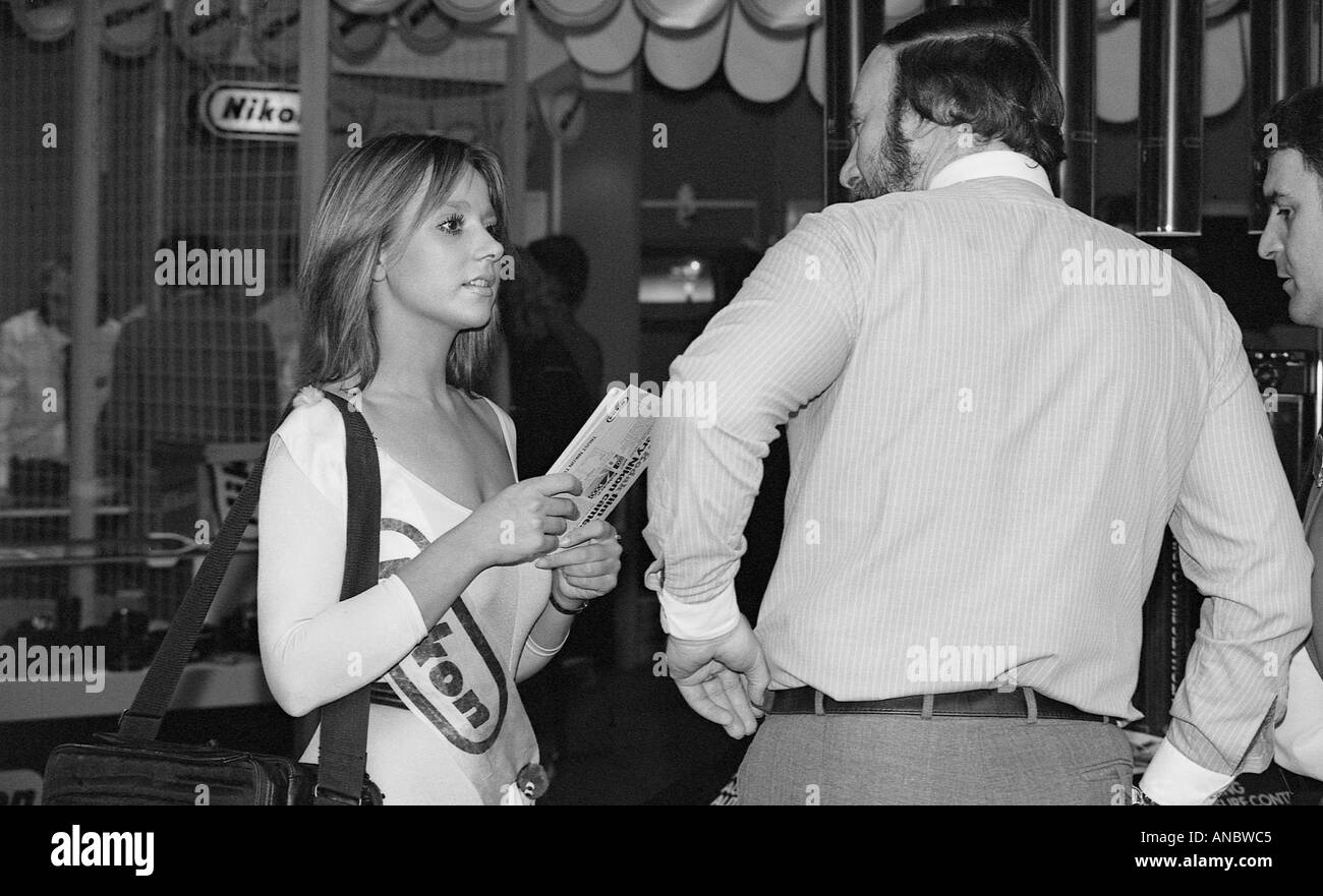 Man talking to a show girl handing out leaflets at the NEC in Birmingham Stock Photo