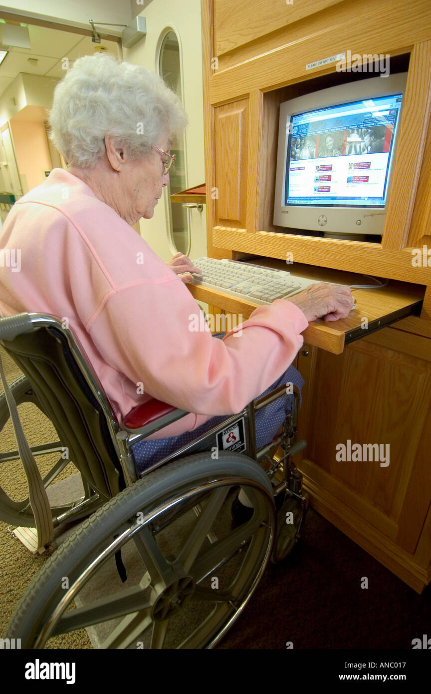 Senior Female Rehabilitates After Suffering Stroke by using the computer and surfing on the internet Stock Photo