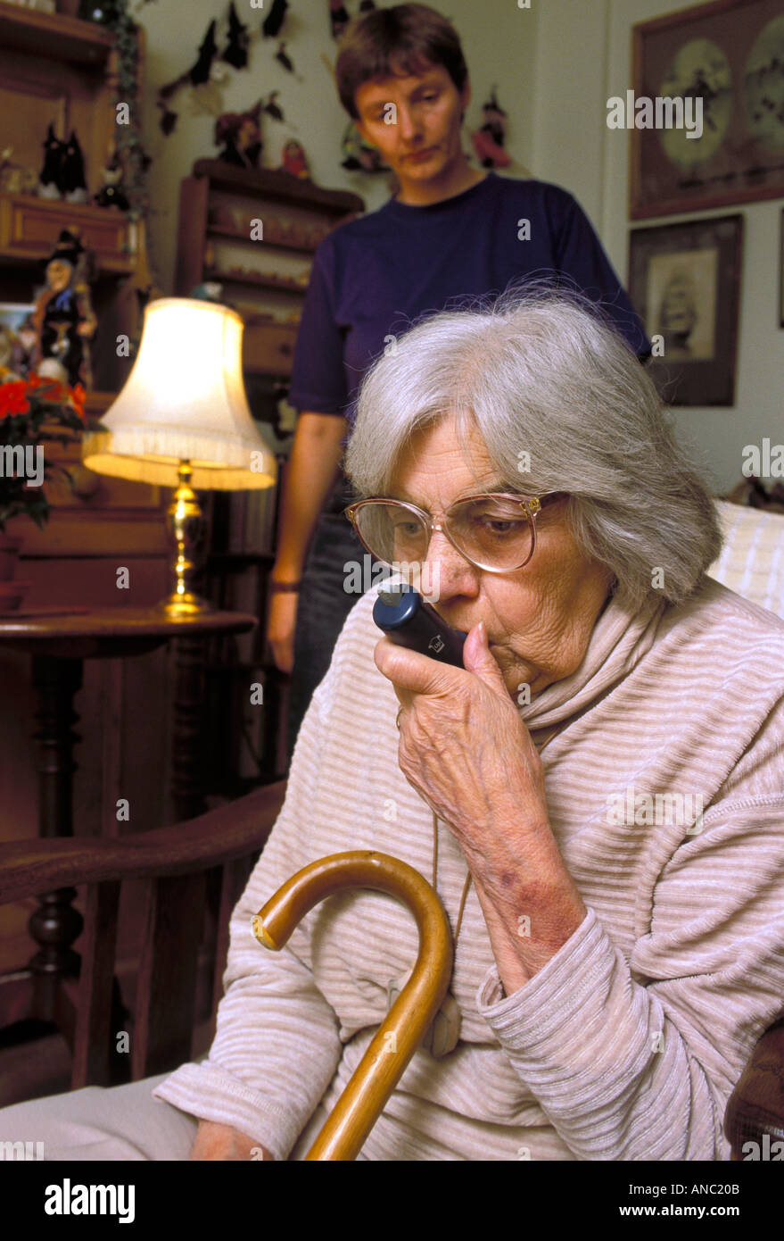 Elderly woman with breathing problems uses a medical puffer in her own