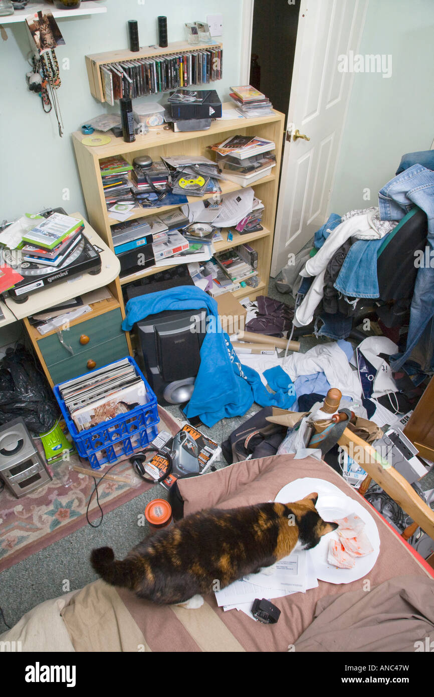 A MALE TEENAGERS BEDROOM IN A MESS WITH CLOTHES AND RUBBISH LYING