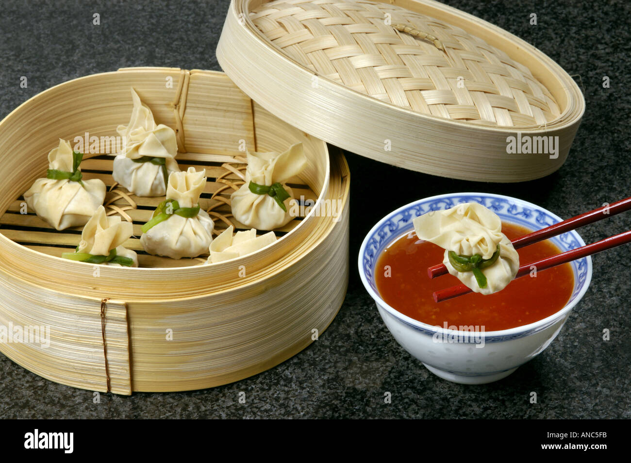 DIM SUM prepared in bamboo steamer with red hot sauce steam eat food