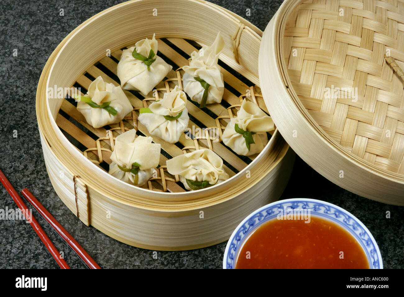 DIM SUM prepared in bamboo steamer with red hot sauce steam eat food