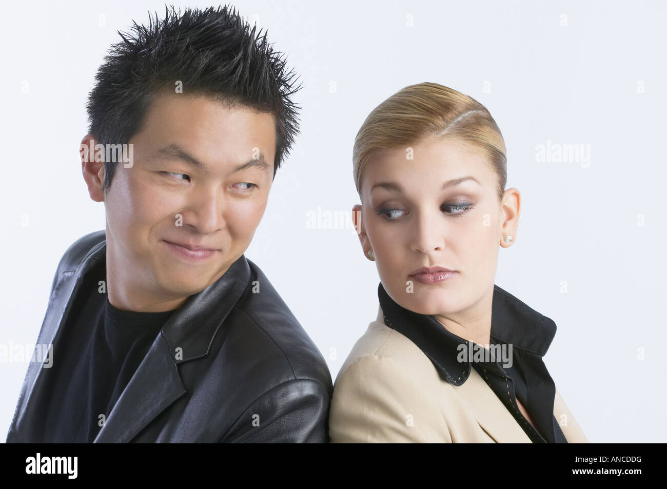 Young couple looking over shoulder at each other Stock Photo