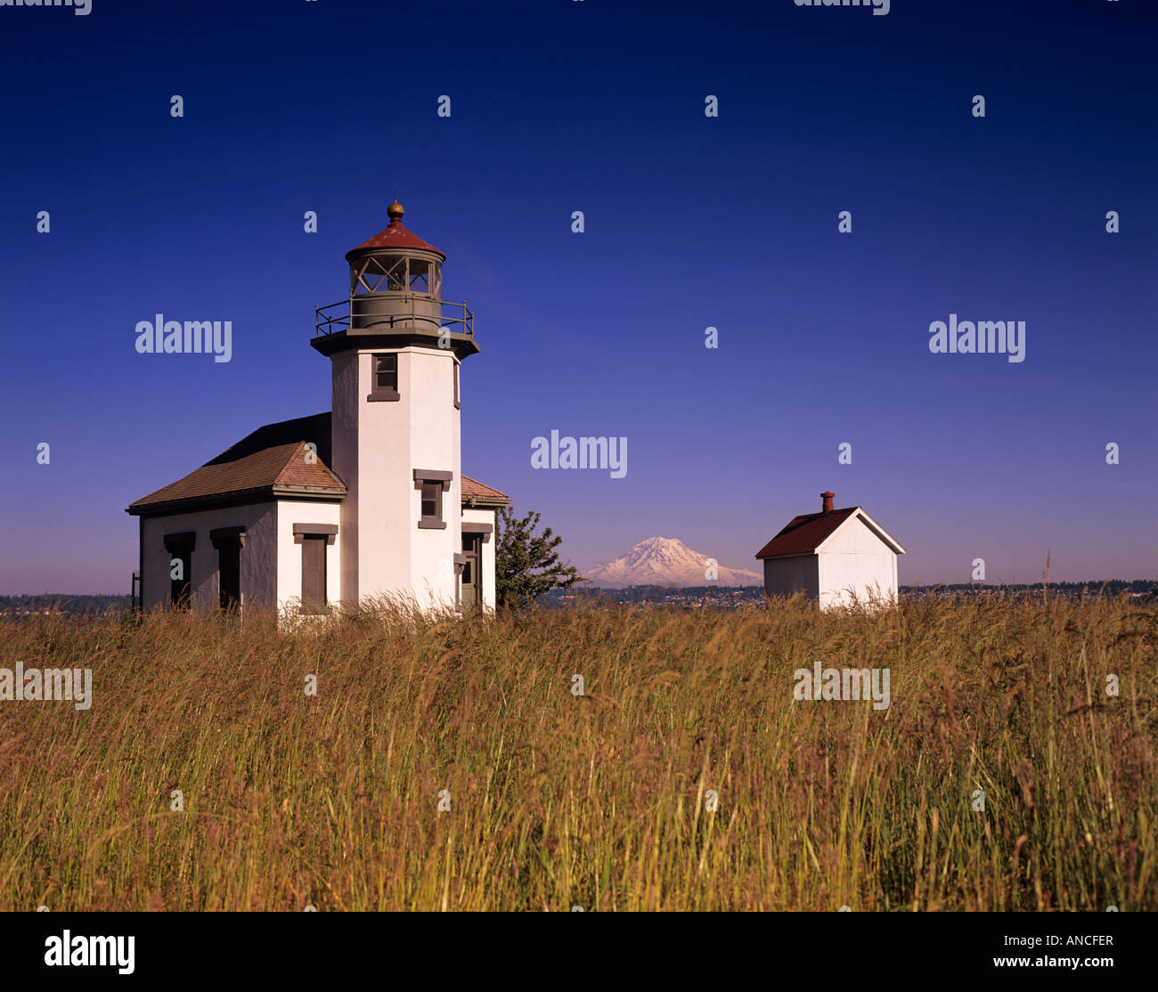 WA, Maury Island, Point Robinson Lighthouse, established 1885, built 1915, with Mt. Rainier Stock Photo