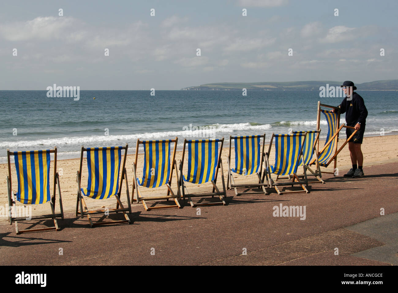 Deck chair attendant arranging deck chairs, Bournemouth seafront