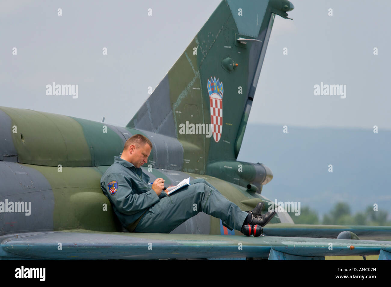 Croatian Air Force MiG-21 BISD fighter, Pleso AFB during 'open day' visit in 2007, pilot is writing notes while sitting on wing Stock Photo