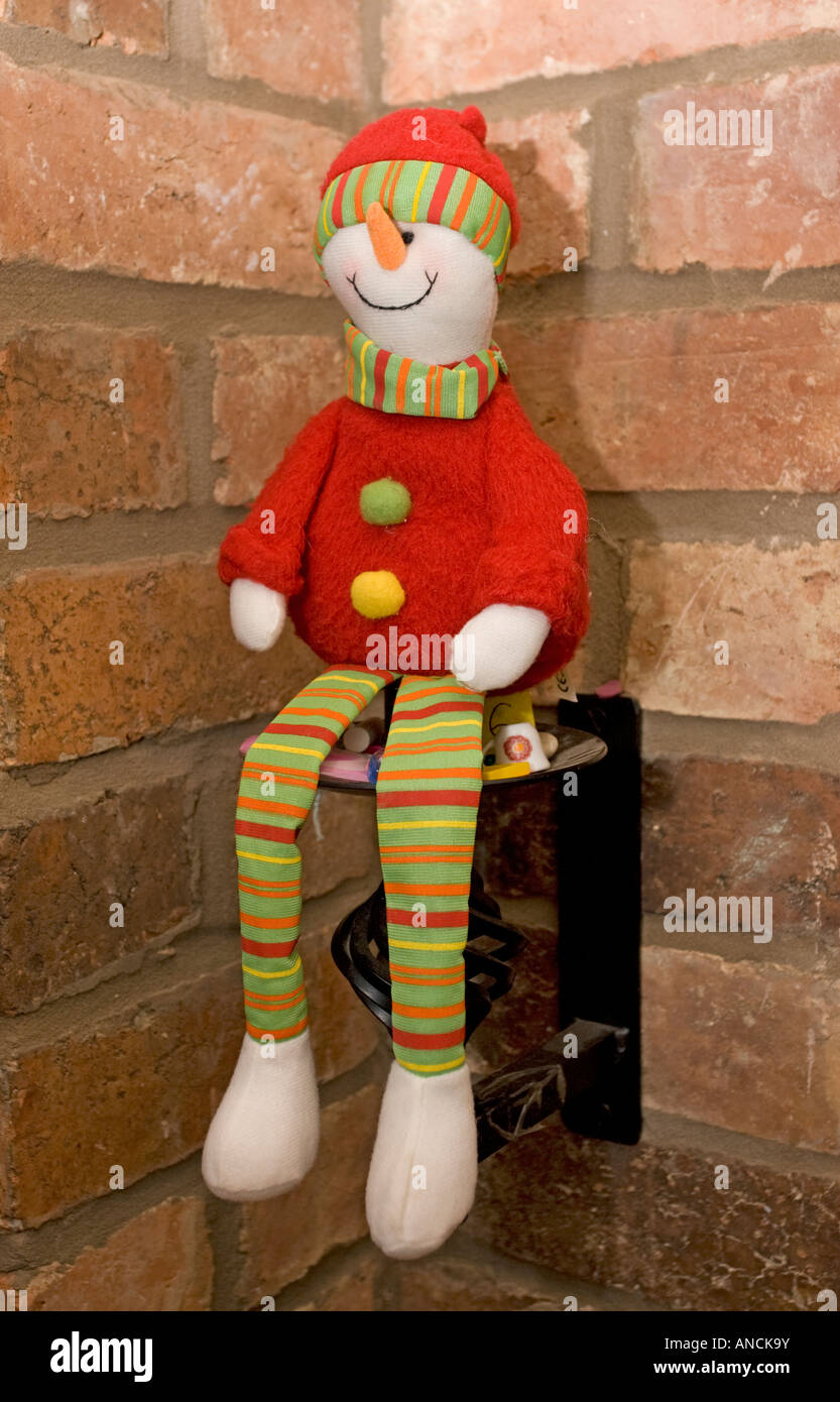 Floppy soft toy clown decoration red coat striped trousers sitting candle bracket Stock Photo