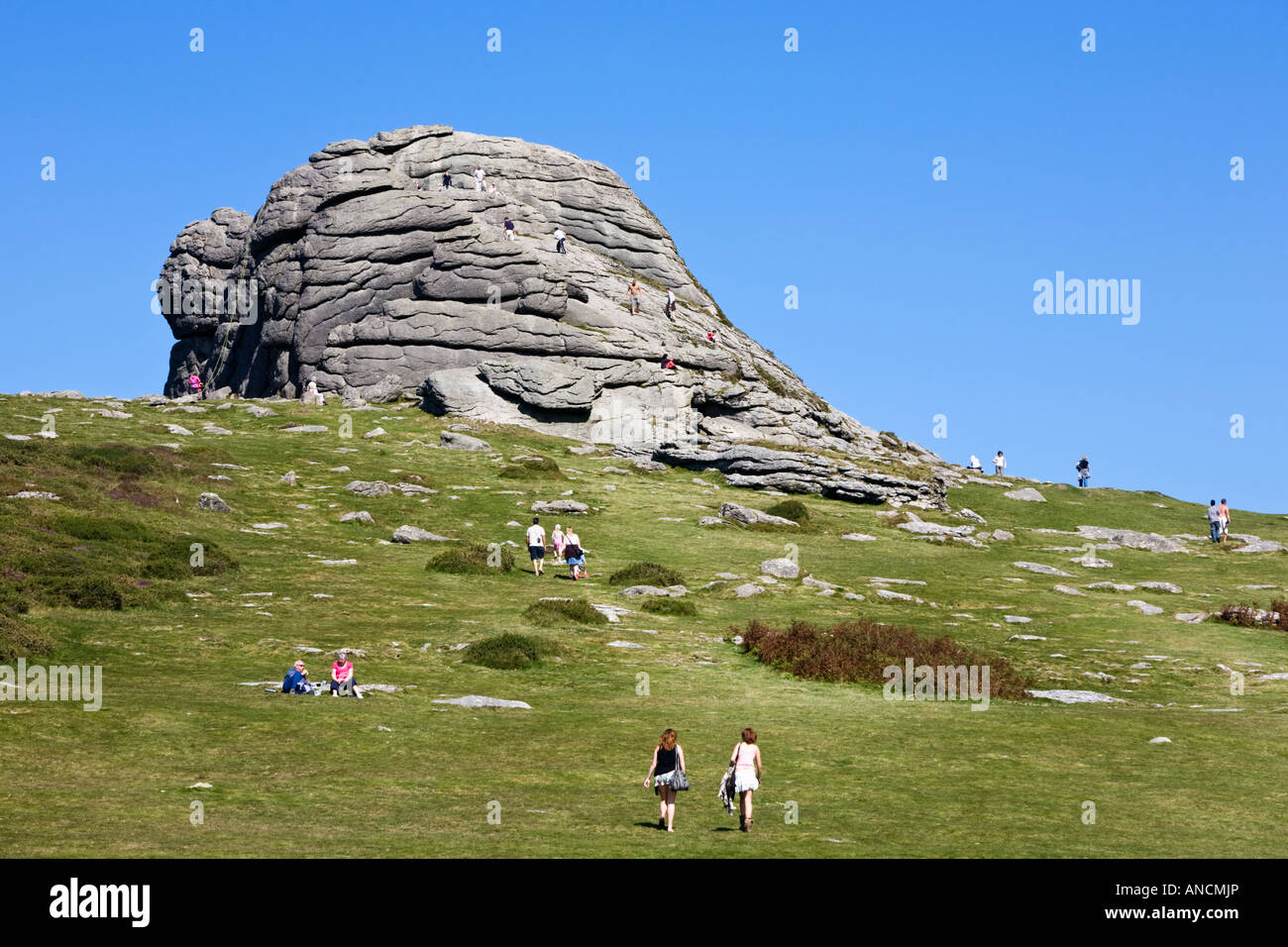 Tourists visiting Hay Tor rock formation on Dartmoor Devon England UK Stock Photo