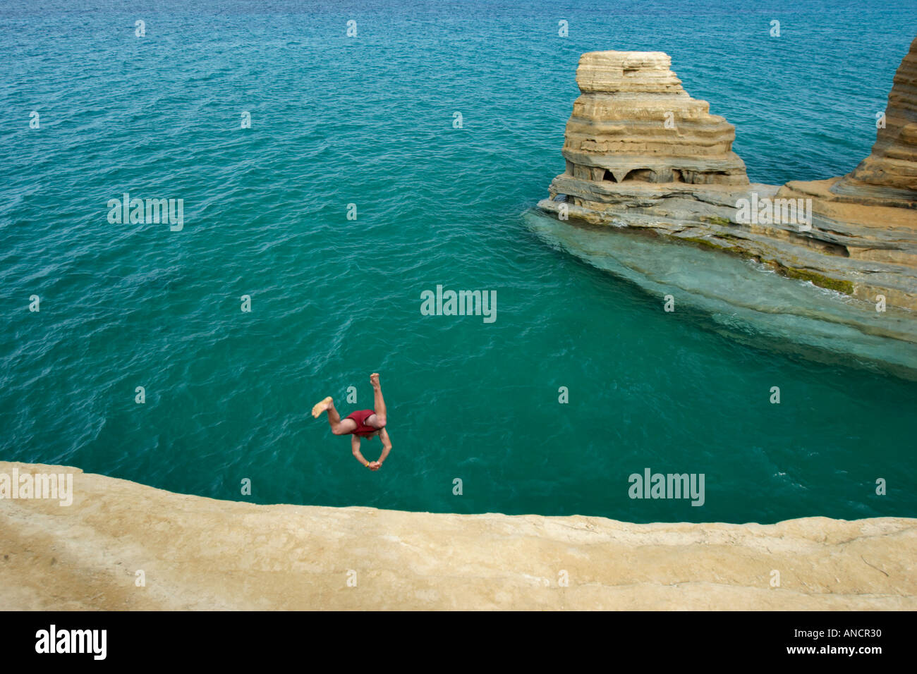A man dives from a cliff near Sidari village. Corfu, Greece. Stock Photo