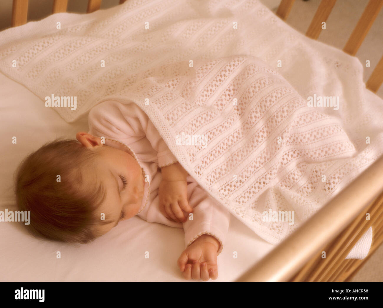 Baby girl sleeping in her cot Stock Photo Alamy