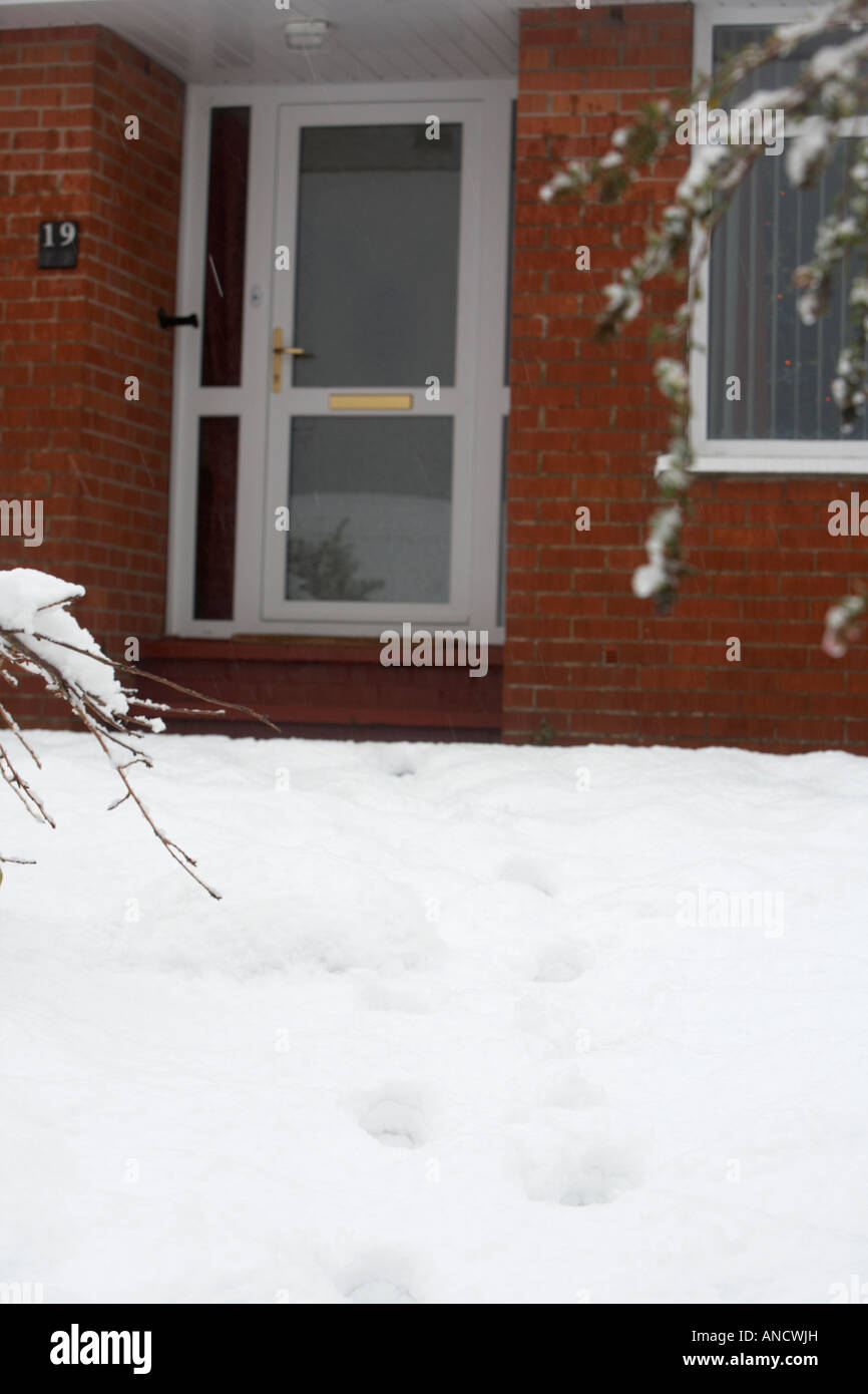 footsteps through heavy snowfall up to double glazed door of a house Stock Photo