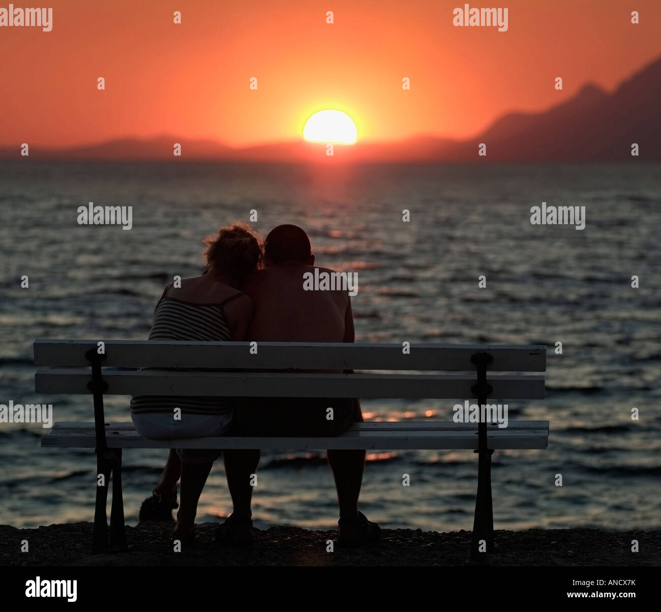 Couple Watching the Sunset over the Mediterranean Ocean Stock Photo