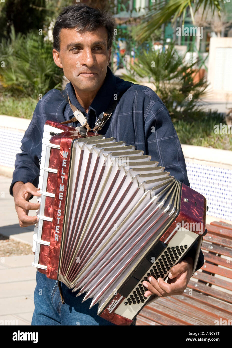 An accordian player performing in the open air under the sun at Cartegena, Spain Stock Photo
