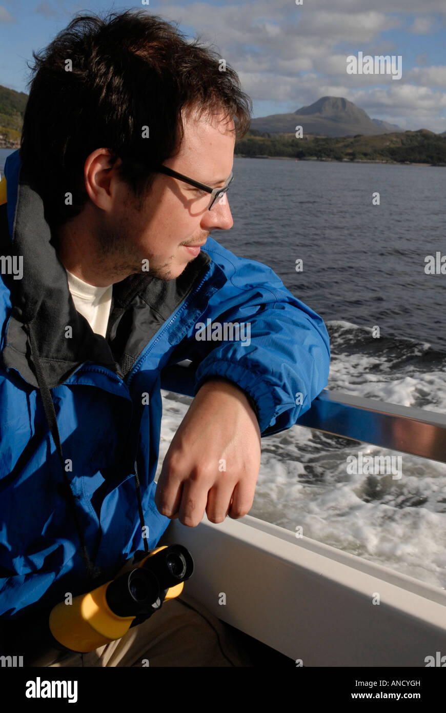 Man looking out towards the sea from the side of a boat Stock Photo - Alamy