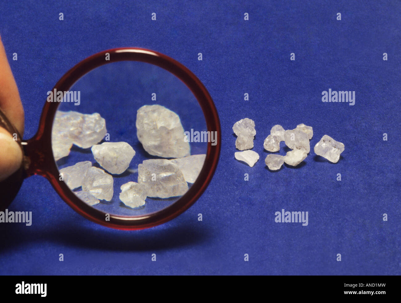 Magnifying glass examines rock salt Stock Photo