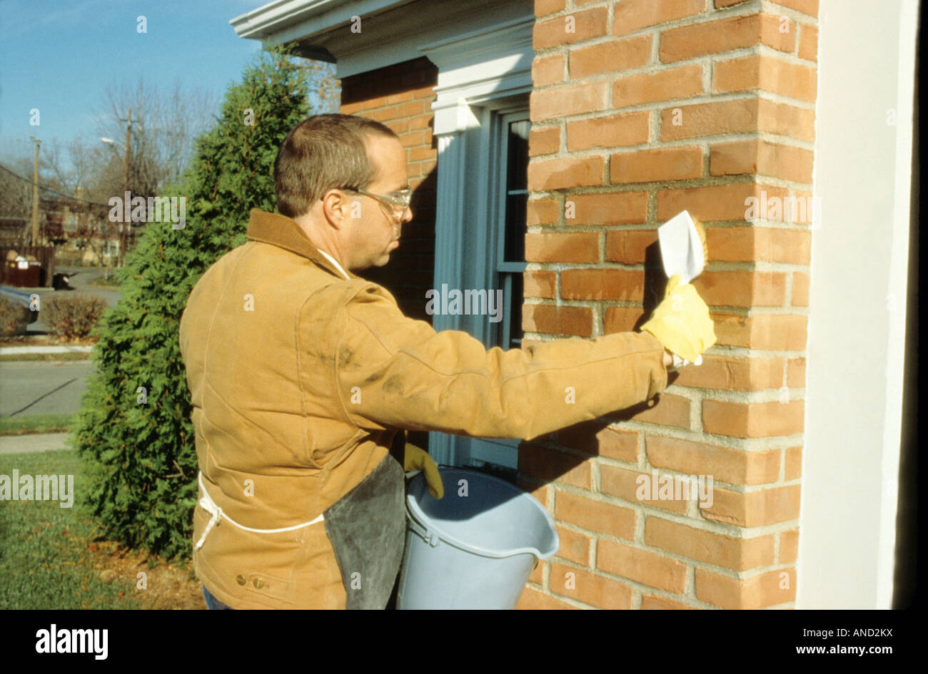 Muriatic acid being used to clean brick mortar, chemical reaction, safety gear goggles gloves, science chemistry Maryland USA Stock Photo