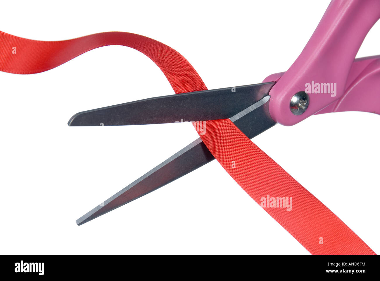 Close up image of an isolated pair of scissors cutting into red ribbon Stock Photo
