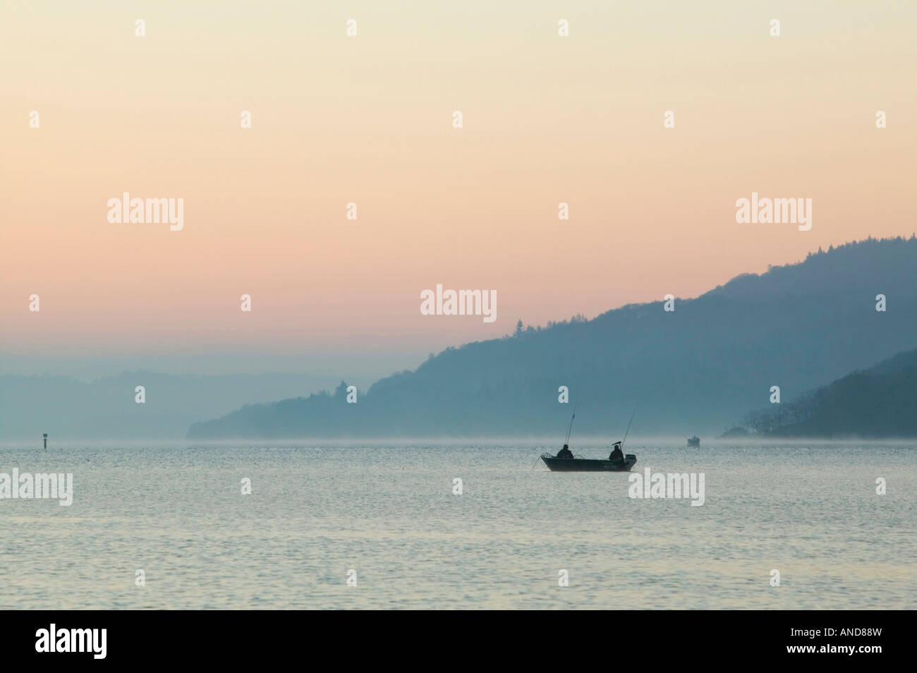 Fishermen fishing for Arctic Char on lake windermere at dawn Lake district National Park UK