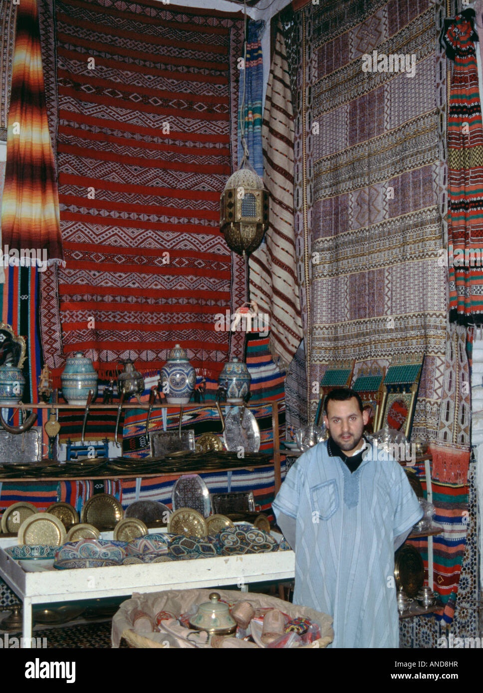 Carpet trader wearing djellaba, at shop in Tetouan Medina, Morocco Stock Photo