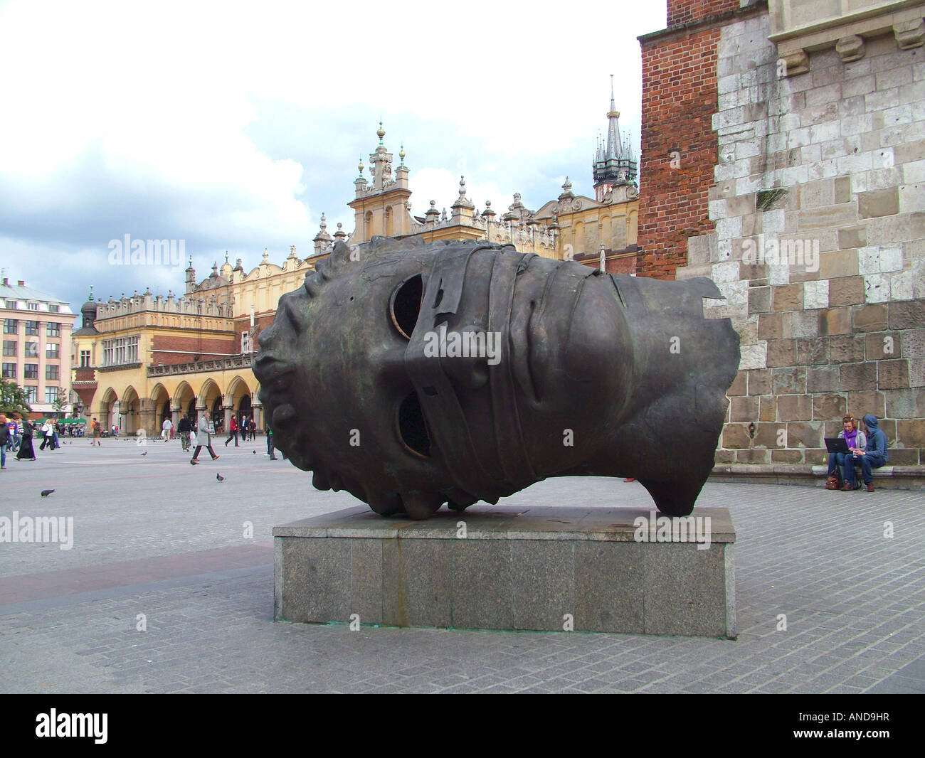 Large male head sculpture outside Cloth Hall, Krakow town square