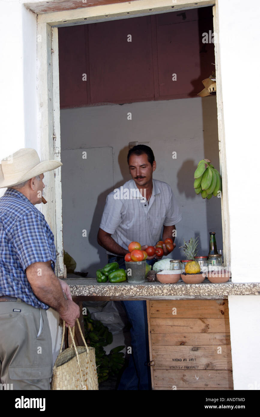 Cuban sells a few items from a doorway in Trinidad Cuba Stock Photo
