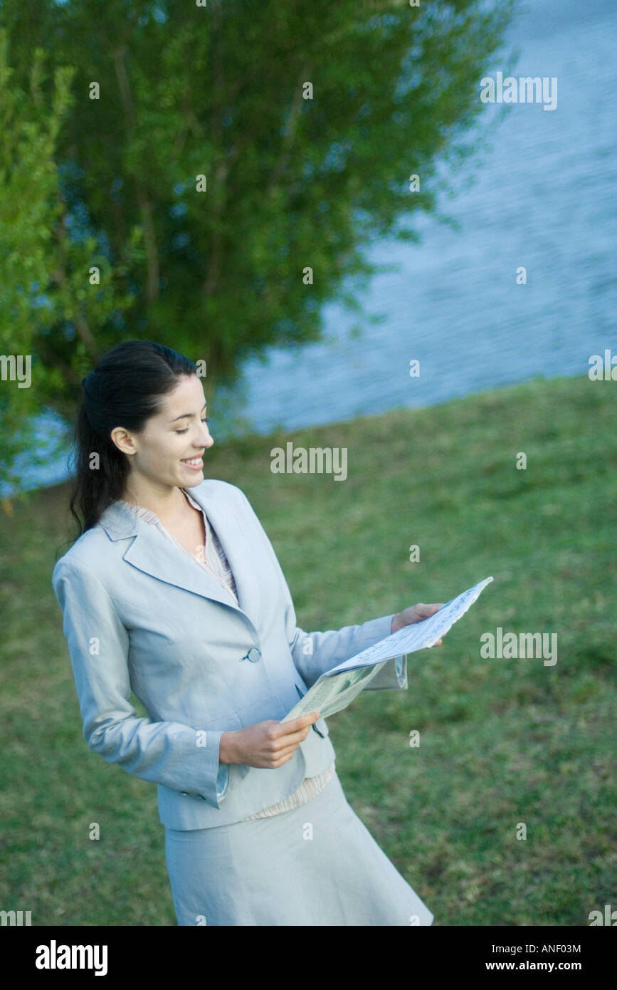 Businesswoman reading newspaper in park Stock Photo