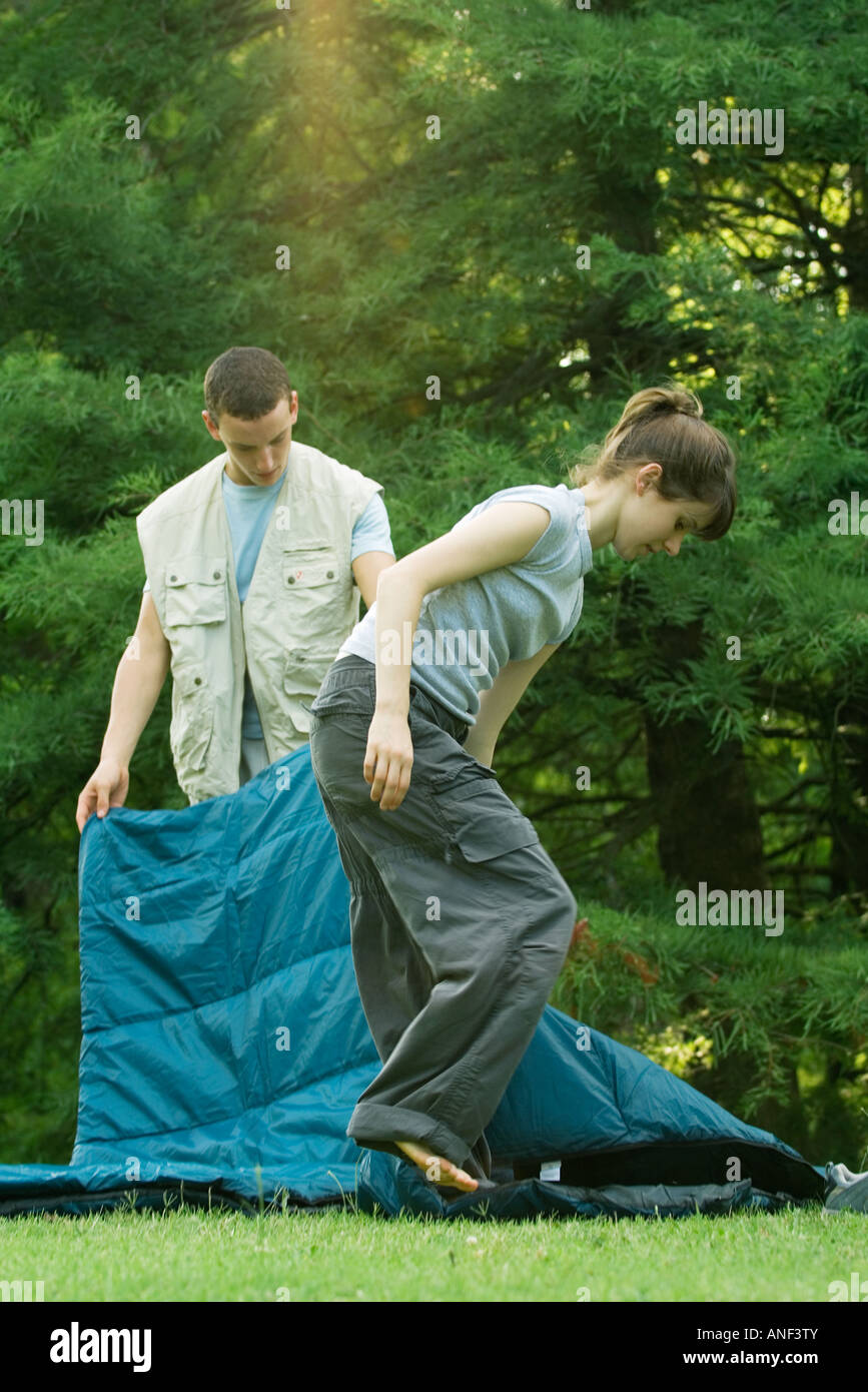 Young campers putting away sleeping bags Stock Photo Alamy