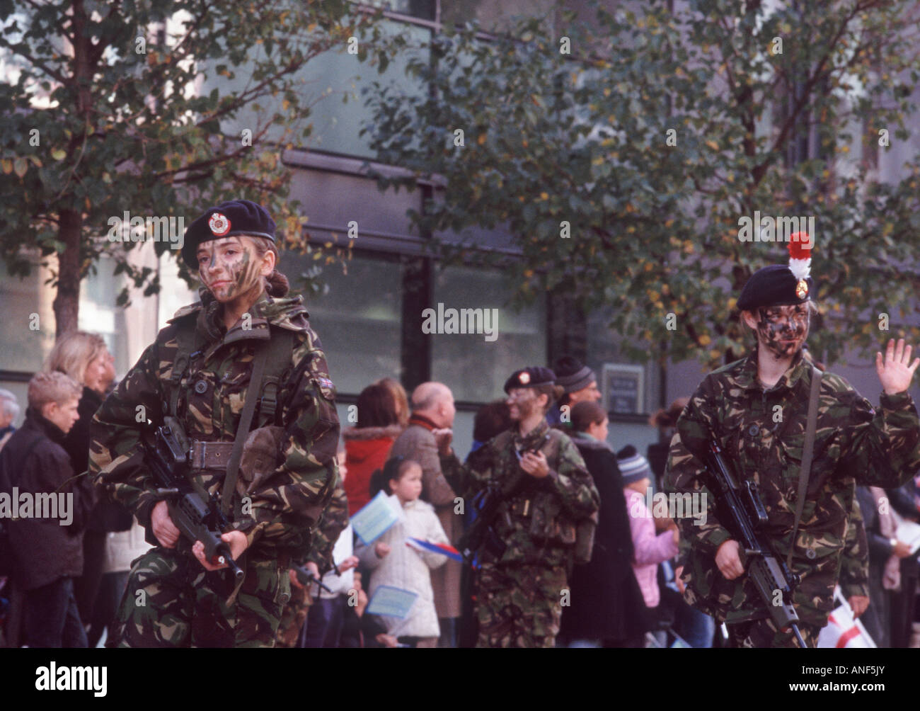 Young women army soldiers of British Armed Forces in camoflage fatigues and face paint with automatic weapons, London Stock Photo