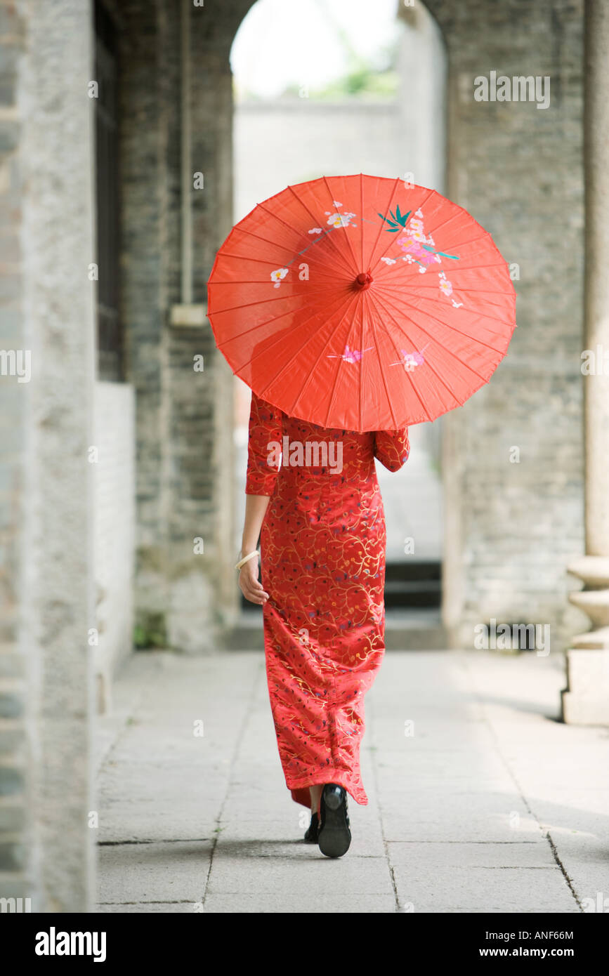 Young woman dressed in traditional Chinese clothing walking with parasol,  rear view Stock Photo - Alamy