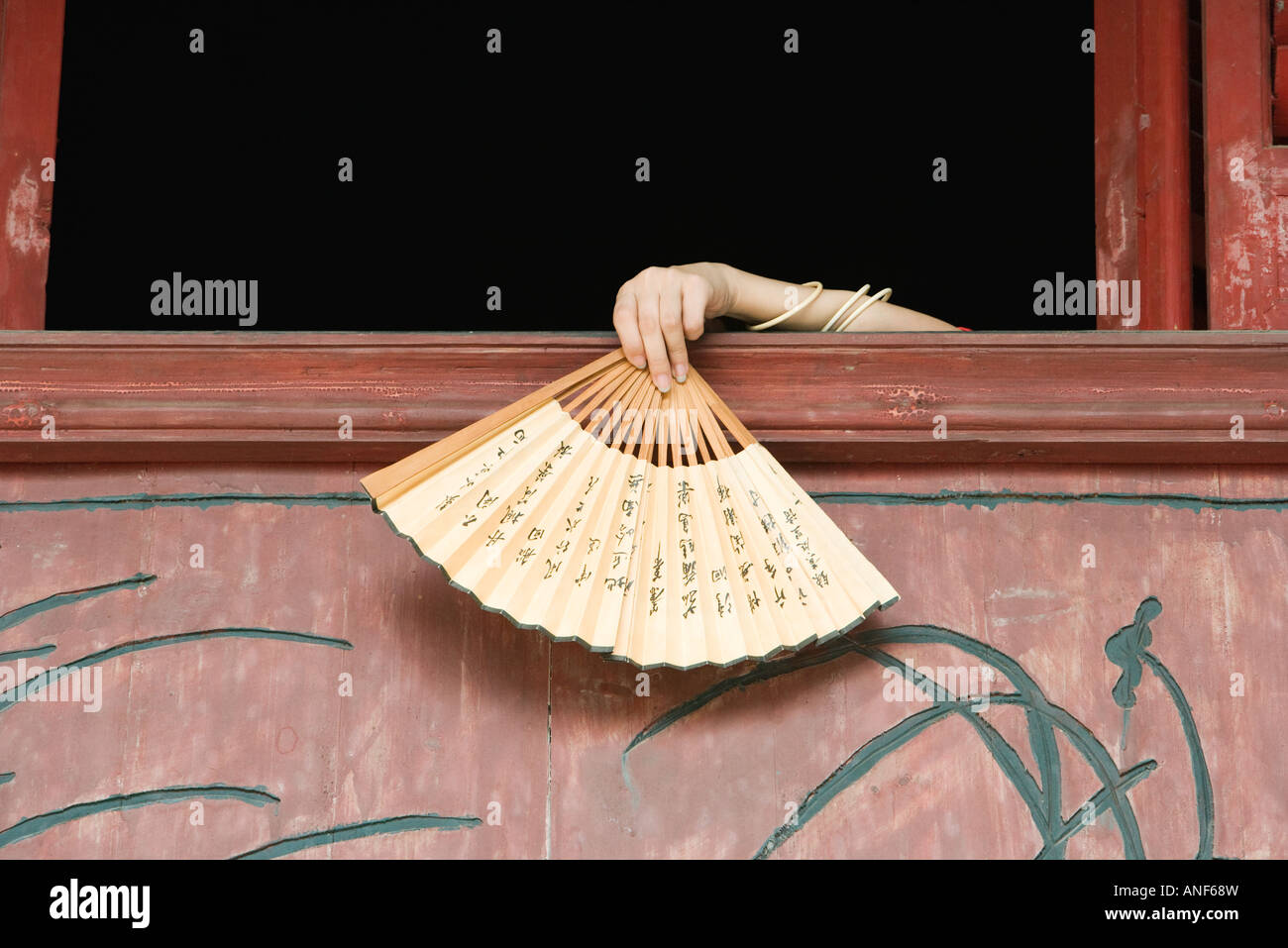 Woman's hand holding fan over edge of windowsill Stock Photo Alamy