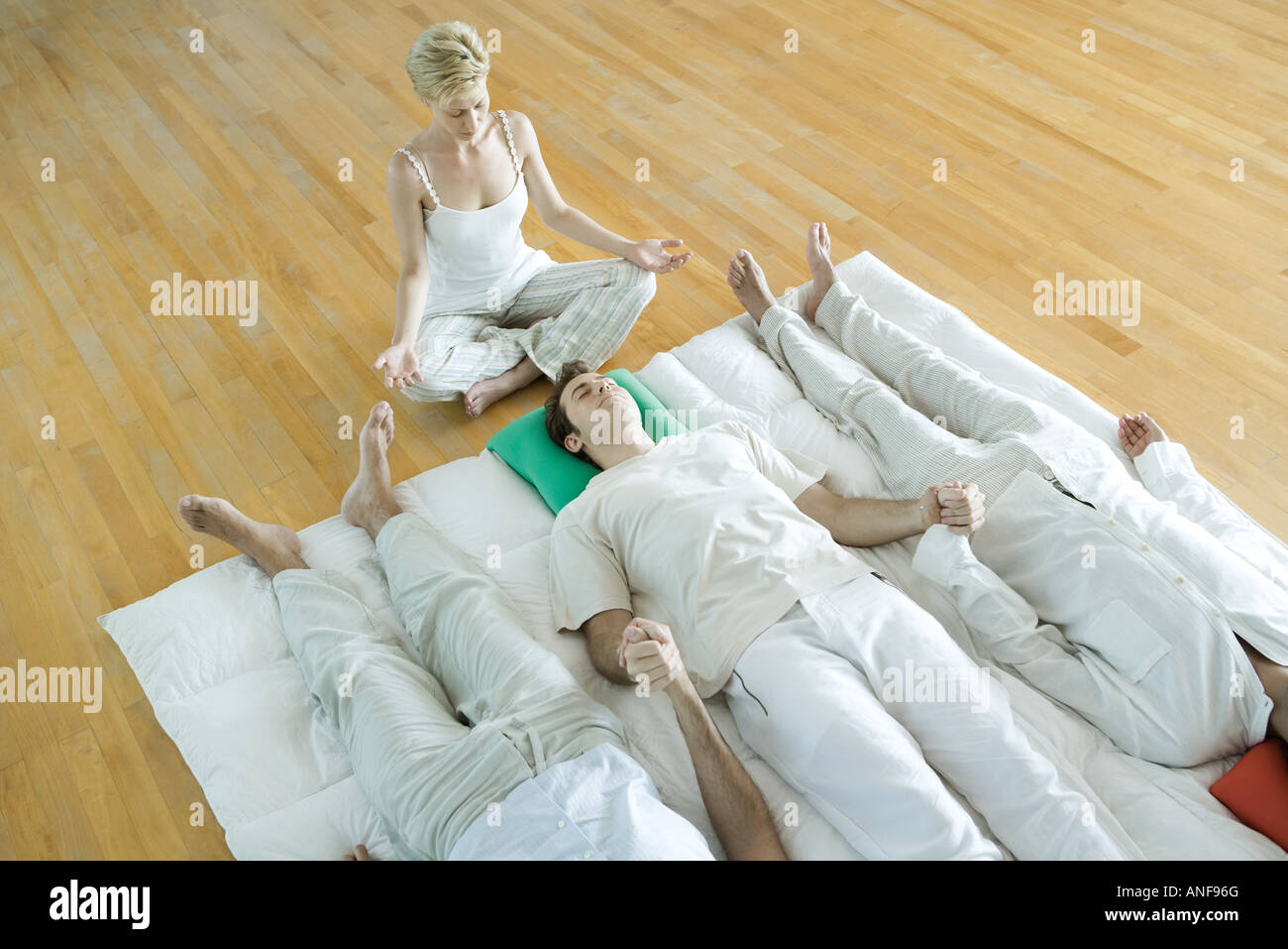 Alternative therapy session, three adults lying side by side while ...