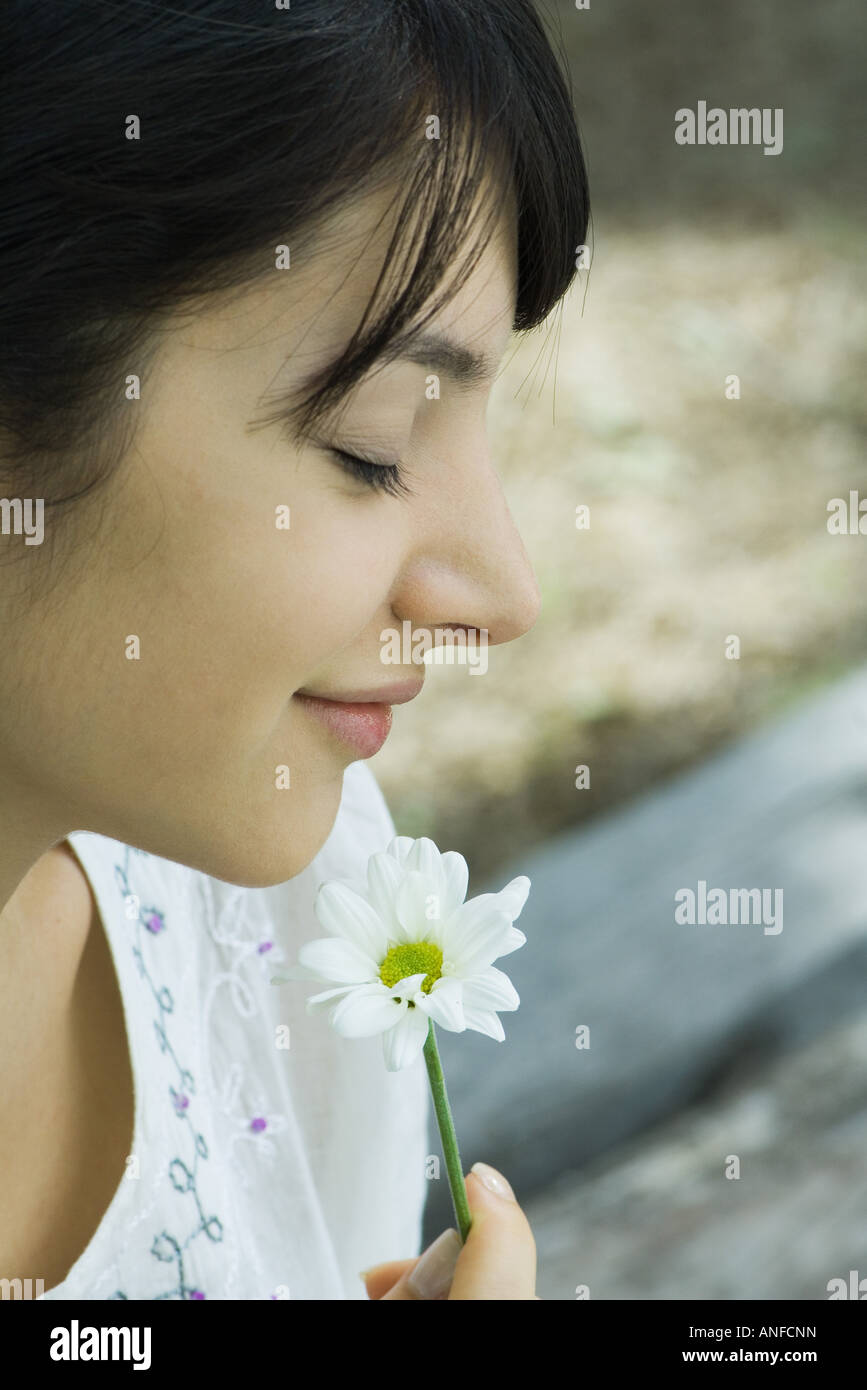 Young woman smelling flower with eyes closed, profile Stock Photo - Alamy