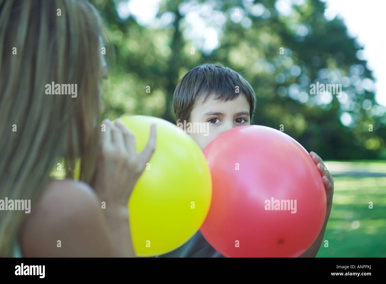 Boy and mother blowing up balloons Stock Photo