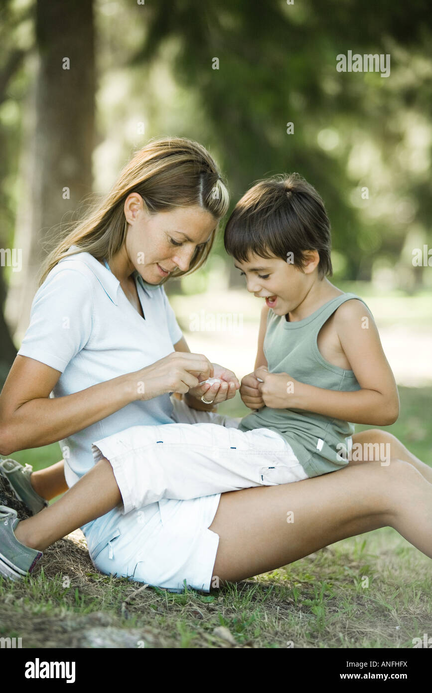 Mother and son sitting outdoors, playing together Stock Photo