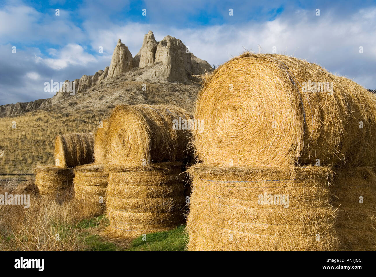 Hay bails create a foreground for hoodoos just East of Kamloops, British Columbia, Canada. Stock Photo
