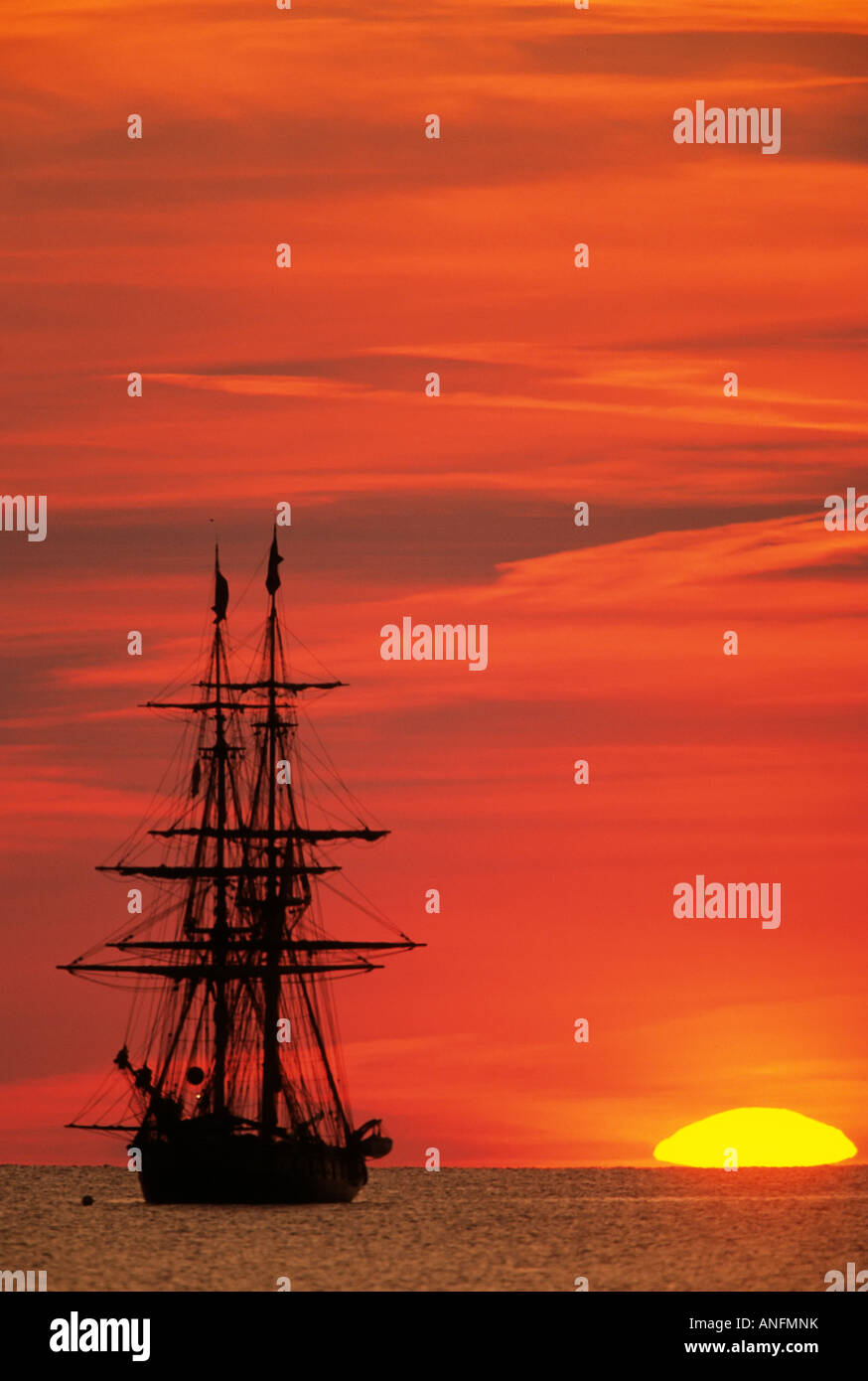 The sunsets next to the tall ship Niagara II, moored off Pelee Island in Lake Erie, Ontario, Canada. Stock Photo