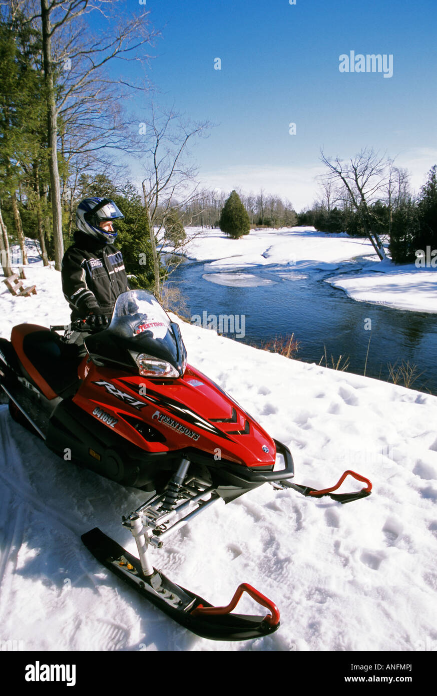 A snowmobiler cruised through a wooded trail on the Bruce Peninsula, Ontario, Canada. Stock Photo