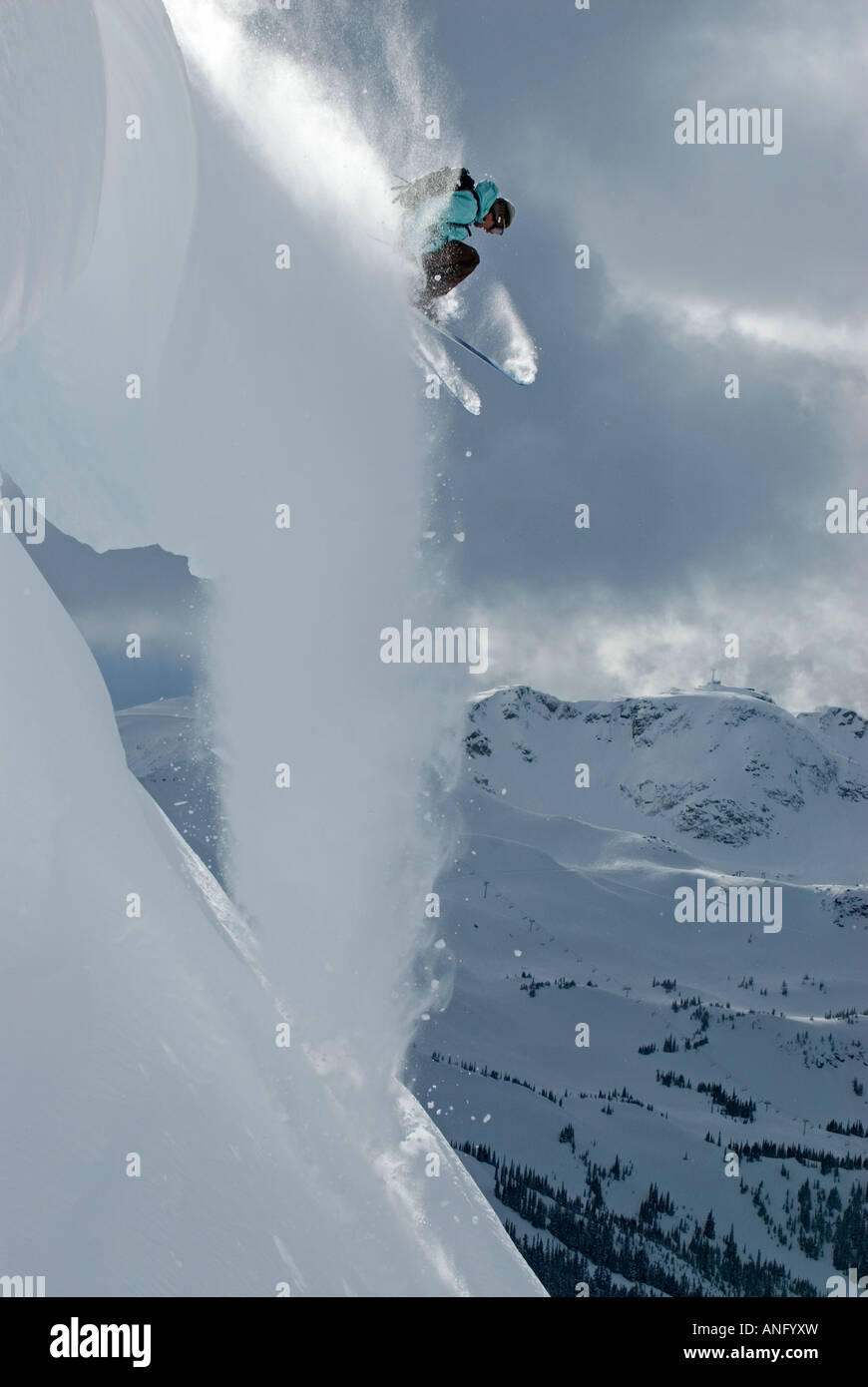 A daring skier takes the plunge off a cornice in the backcountry of Blackcomb Mountain, British Columbia, Canada. Stock Photo